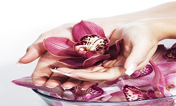 Spa and wellness details. Woman hands with orchids