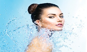 Beautiful Model Woman with splashes of water in her hands. Beaut